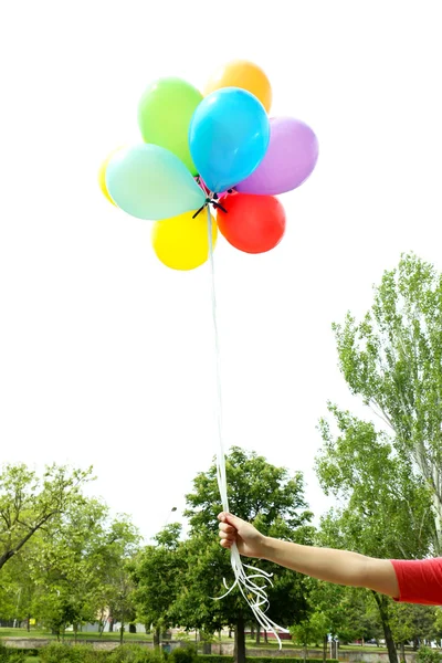 Balloons in hand, outdoors — Stock Photo, Image