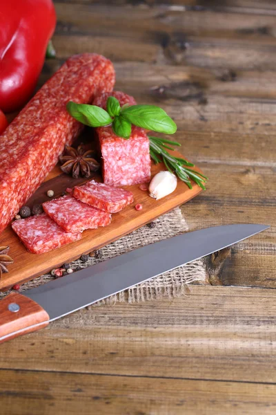 Kiełbasa salami smaczny i przyprawy na drewniane tła — Zdjęcie stockowe