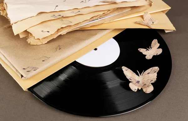 Oude vinyl record met oud papier en vlinders, op bruine achtergrond — Stockfoto