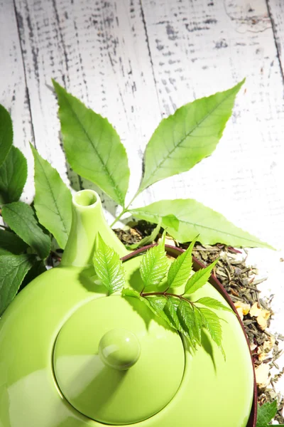 Natürlicher Kräutertee mit trockenen Blüten und Kräuterzutaten, auf farbigem Holzgrund — Stockfoto