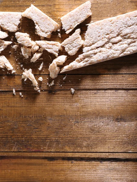 Crushed dietic rye bread on wooden background — Stock Photo, Image