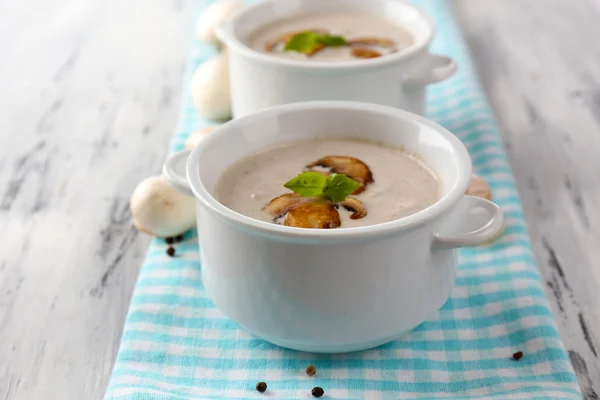 Грибной суп в белых горшках, на салфетке, на деревянном фоне — стоковое фото