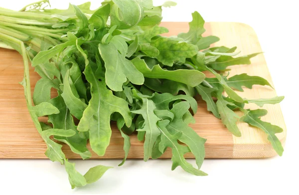 Fresh rucola salad or rocket lettuce leaves on wooden board isolated on white — Stock Photo, Image