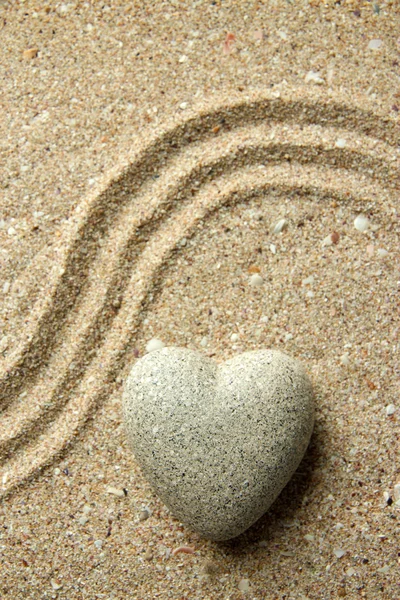 Grey zen stone in shape of heart, on sand background — Stock Photo, Image