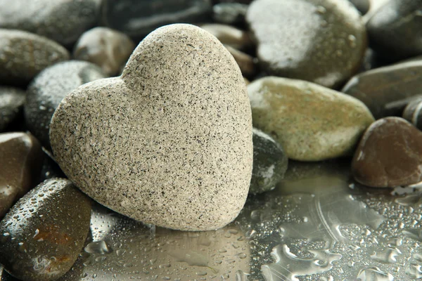 Pietra grigia a forma di cuore, su sfondo chiaro — Foto Stock