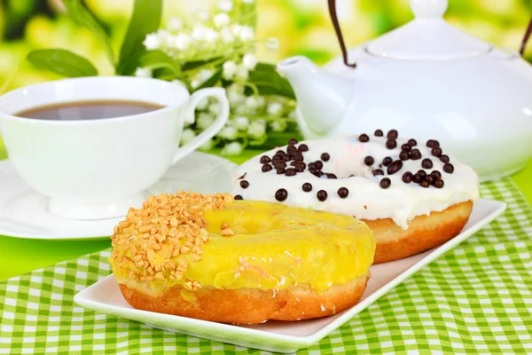 Doce donuts com xícara de chá na mesa close-up — Fotografia de Stock
