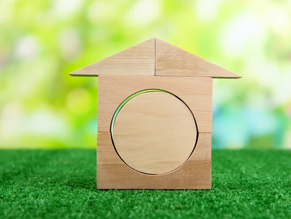 Houten huis op gras op natuurlijke achtergrond — Stockfoto