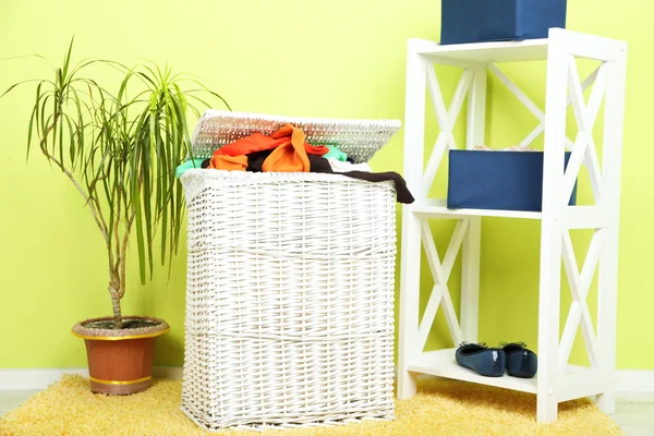 充分的洗衣篮，在家庭内部的背景上的木地板上 — 图库照片
