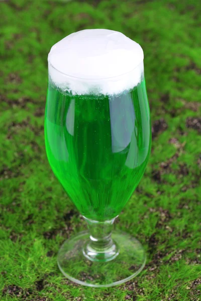 Bicchiere di birra verde per il giorno di San Patrizio sull'erba primo piano — Foto Stock