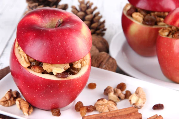 Fyllda äpplen med nötter och kanel på tallriken på bordet på nära håll — Stockfoto