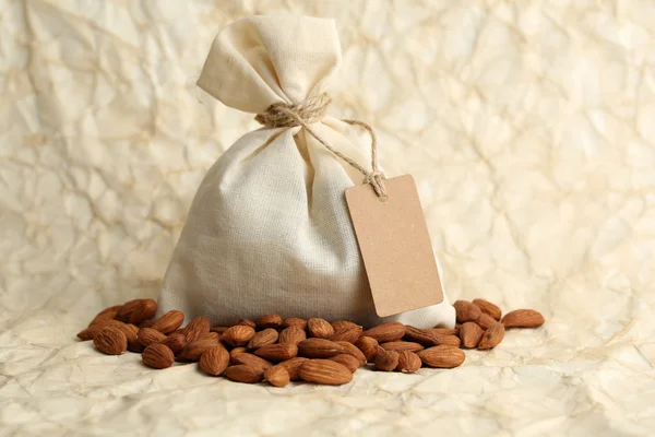 Almendras en saco con etiqueta sobre fondo de papel viejo —  Fotos de Stock