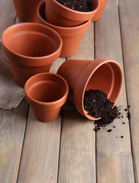 Pots de fleurs en argile et terre, sur table en bois — Photo