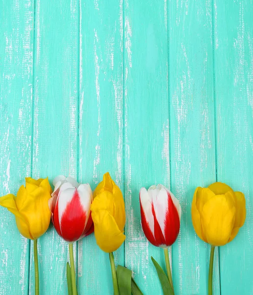 Lindas flores na cor de fundo de madeira — Fotografia de Stock