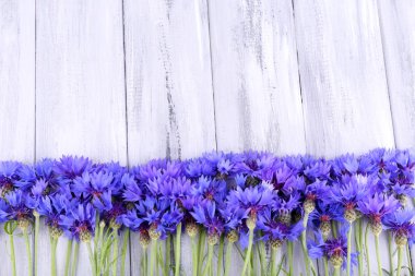 Beautiful cornflowers on wooden background clipart