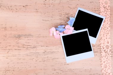 Boş eski fotoğraflar ve renkli ahşap arka planda dekoratif kurdele