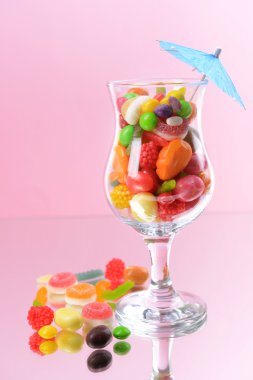 Pembe arka planda camda farklı renkte meyve şekeri