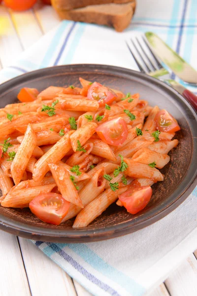 Pasta med tomatsås på tallriken på bordet närbild — Stockfoto