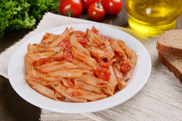 Pasta met tomatensaus op plaat op tabel close-up — Stockfoto