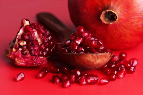Reife Granatäpfel auf rotem Hintergrund — Stockfoto