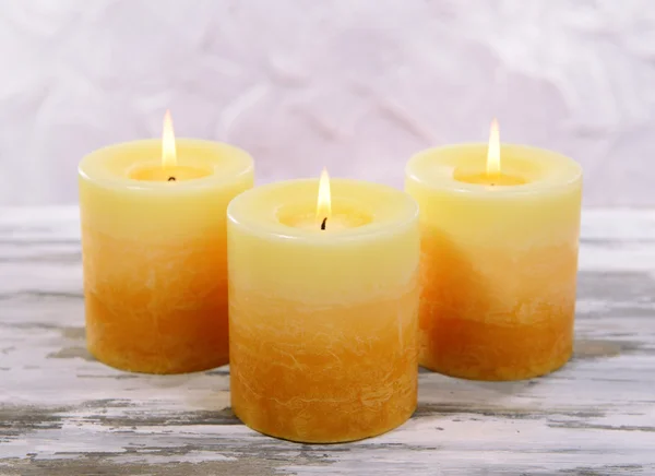 Schöne Kerzen auf Tisch auf grauem Hintergrund — Stockfoto