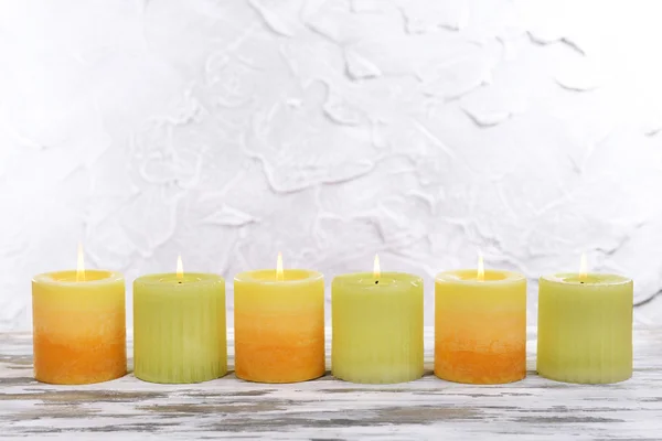 Hermosas velas en la mesa sobre fondo gris — Foto de Stock