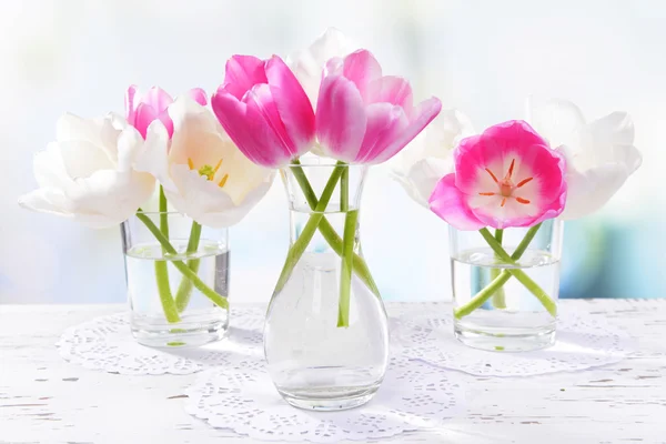 Tulipas bonitas em balde em vaso na mesa no fundo claro — Fotografia de Stock