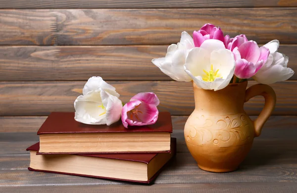 Tulipas bonitas em balde em jarro na mesa em fundo cinza — Fotografia de Stock