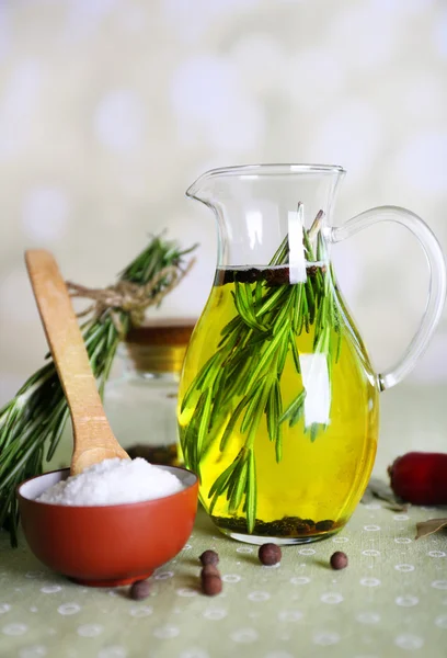 Essential Oil with rosemary in glass jug, on light background — Stock Photo, Image