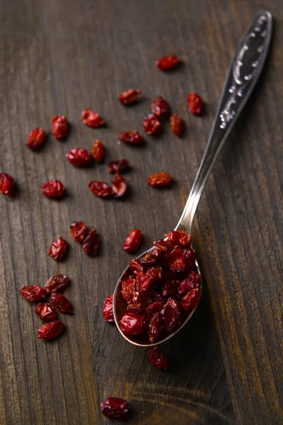 Spice barberry in spoon on wooden background — Stock Photo, Image