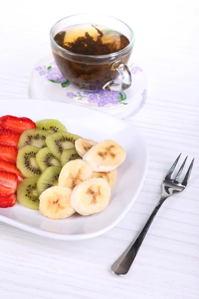 Various sliced fruits on plate on table close-up — Stock Photo, Image