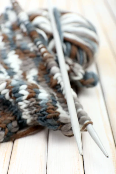 Lavorare a maglia con i raggi su sfondo di legno — Foto Stock