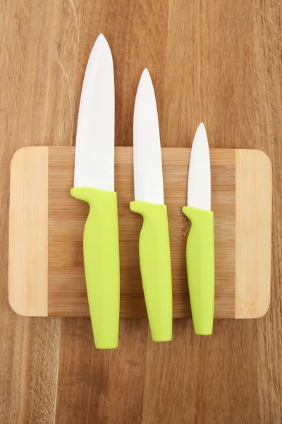 Kitchen knives and cutting board on wooden table — Stock Photo, Image