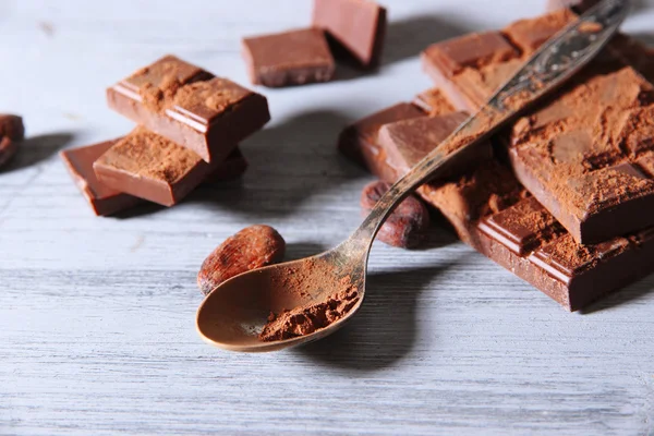 Cacao en polvo y chocolate negro sobre fondo de madera de color —  Fotos de Stock