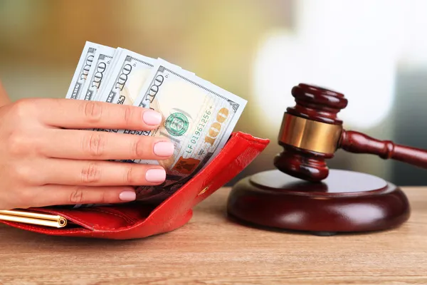 Gavel and hand holding money in wallet on wooden background — Stock Photo, Image