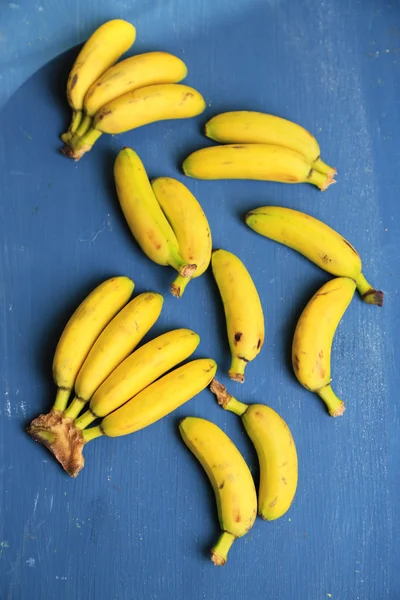Bunch of mini bananas on color wooden background — Stock Photo, Image