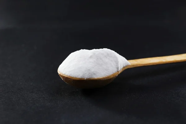 Spoon of baking soda on black background — Stock Photo, Image