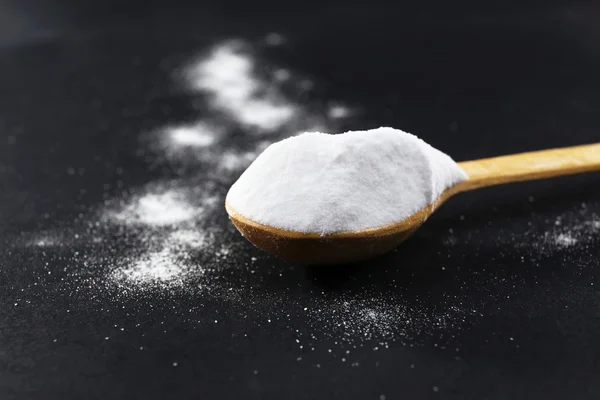 Spoon of baking soda on black background — Stock Photo, Image