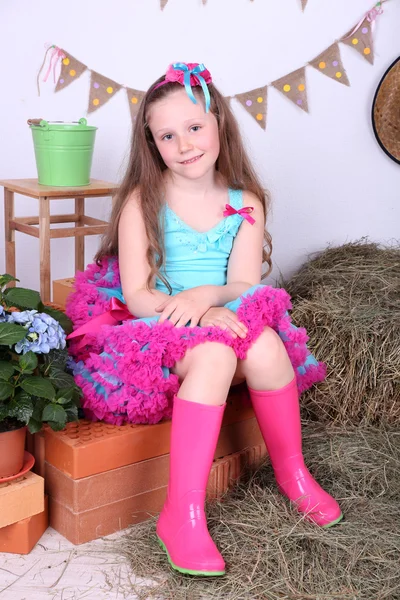 Schöne kleine Mädchen im kleinen Rock auf Landhausstil Hintergrund — Stockfoto