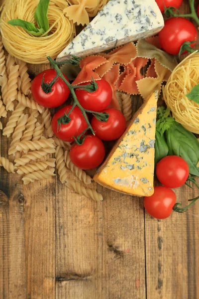 Différentes pâtes, fromages et tomates sur table en bois close-up — Photo