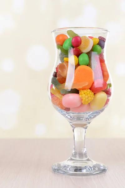 Verschillende kleurrijke vruchten snoep in glas op tafel op lichte achtergrond — Stockfoto