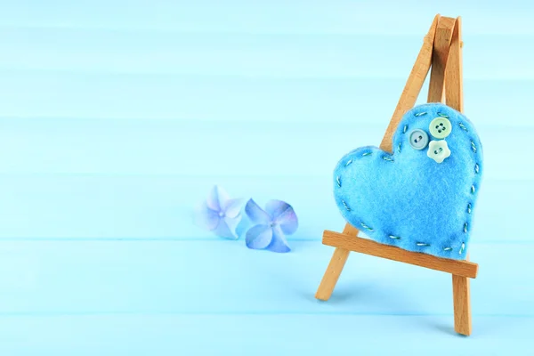 Krásné srdce malé dekorativní stojan na modrém pozadí — Stock fotografie