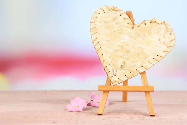 Schönes Herz kleine dekorative Staffelei auf rosa Tisch — Stockfoto