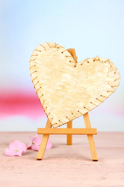 Hermoso corazón pequeño caballete decorativo sobre mesa rosa — Foto de Stock