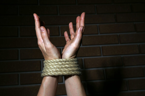 Tied hands on dark background