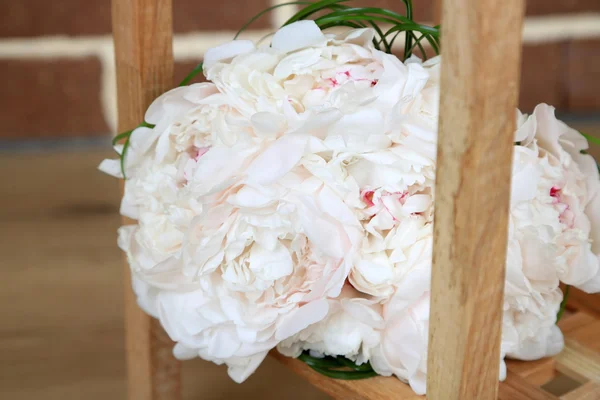 Beautiful wedding bouquet on   wooden stand on bricks background — Stock Photo, Image