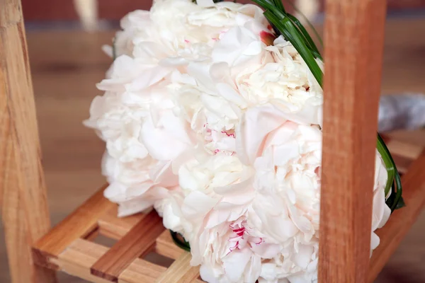 Beautiful wedding bouquet on   wooden stand on bricks background — Stock Photo, Image