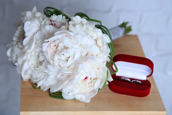 Bellissimo bouquet da sposa su basamento in legno su sfondo parete leggera — Foto Stock