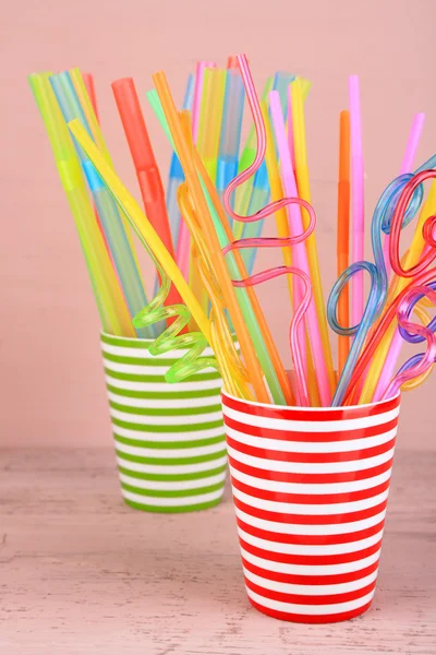 Straws in cups on pink background — Stock Photo, Image