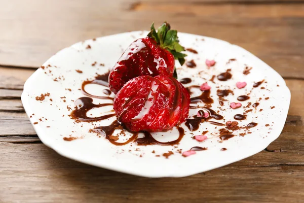 Red ripe strawberries with chocolate on wooden table — Stock Photo, Image