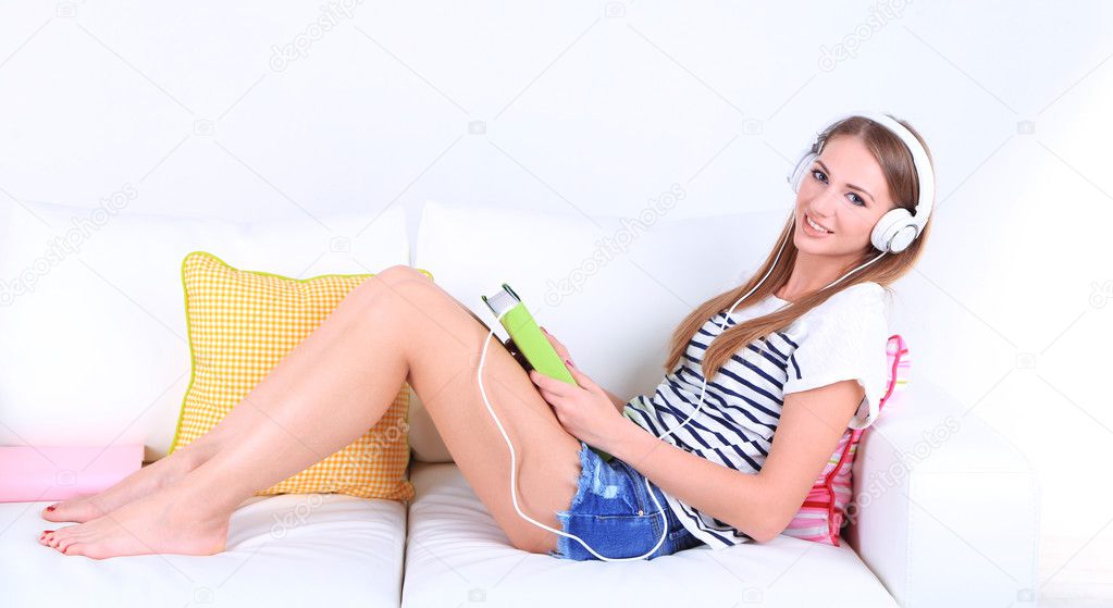 Conceptual image of  audio book.Beautiful girl with book and headphones.